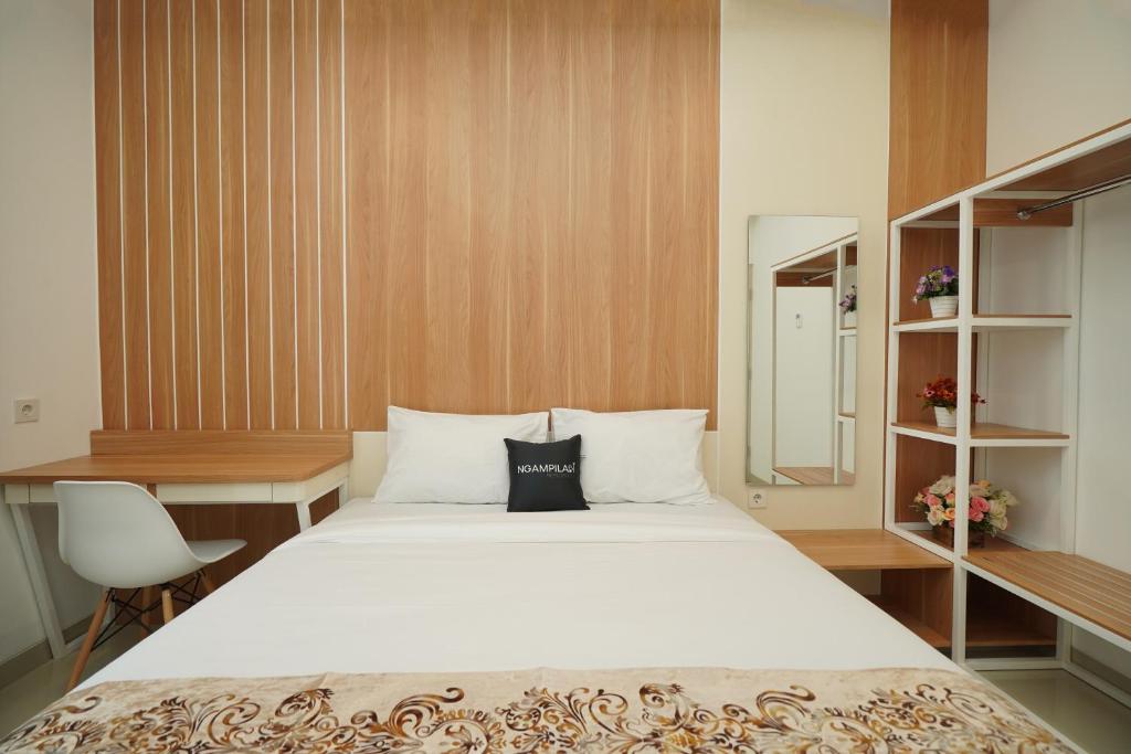 a bedroom with a bed and a desk and a mirror at Ngampilan Residence Yogyakarta Mitra RedDoorz in Ngabean