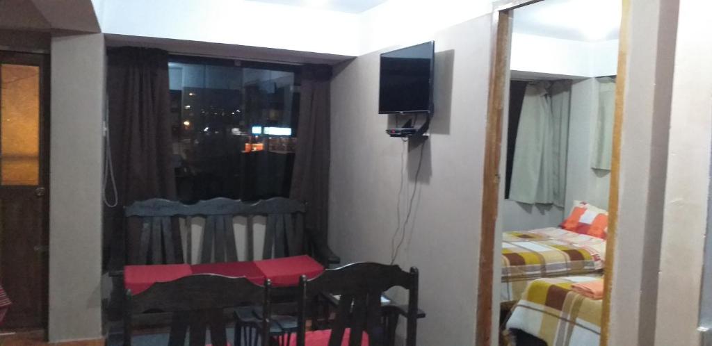 Habitación pequeña con 2 camas y TV. en Aparthotel ANDESITA CUSCO, en Cusco