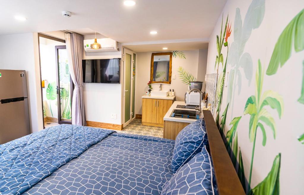 a bedroom with a blue bed and a bathroom at Cherry Apartment - Thao Dien Centre in Ho Chi Minh City
