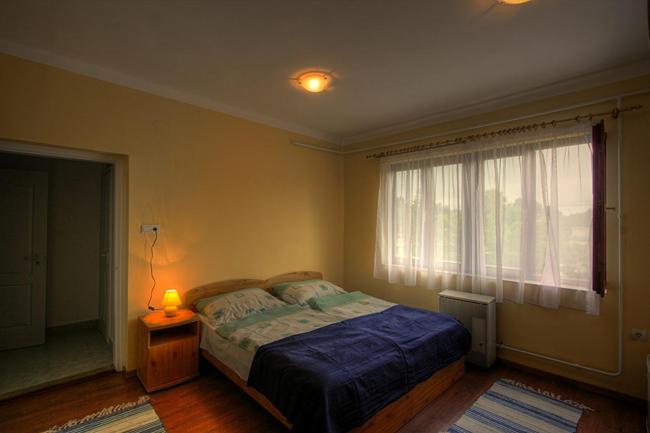 um quarto com uma cama e uma janela em Matróz Siófok em Siófok