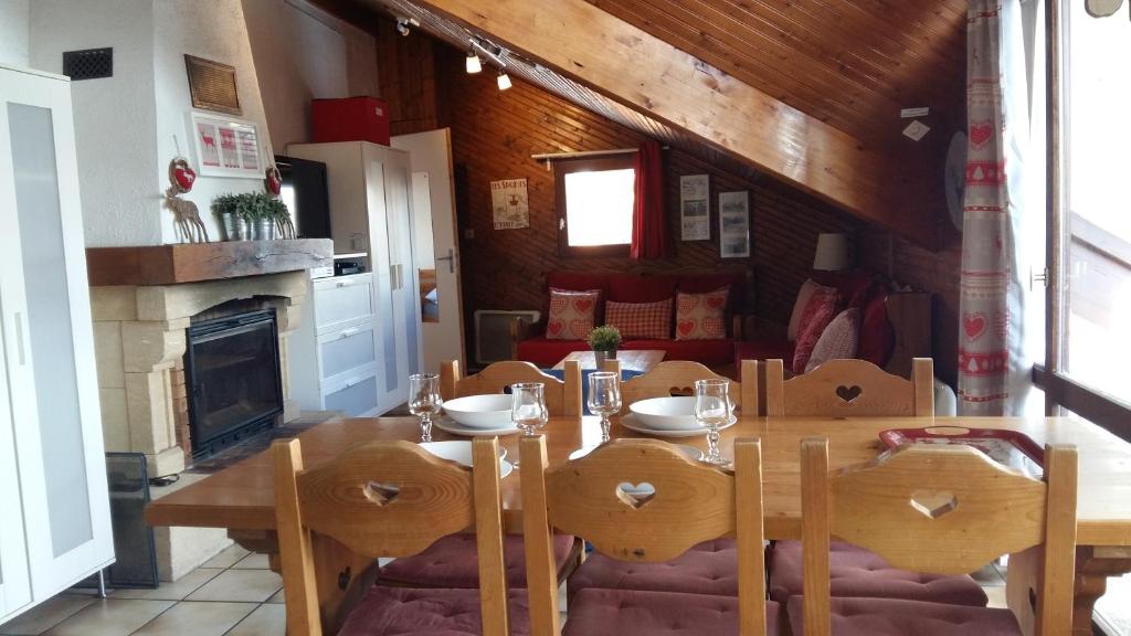 jadalnia ze stołem, krzesłami i kominkiem w obiekcie 13 Lou Veno w mieście Les Deux Alpes