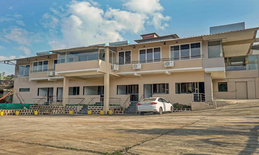 a white car parked in front of a building at Hotel Lake Paradise Mahabaleshwar in Mahabaleshwar