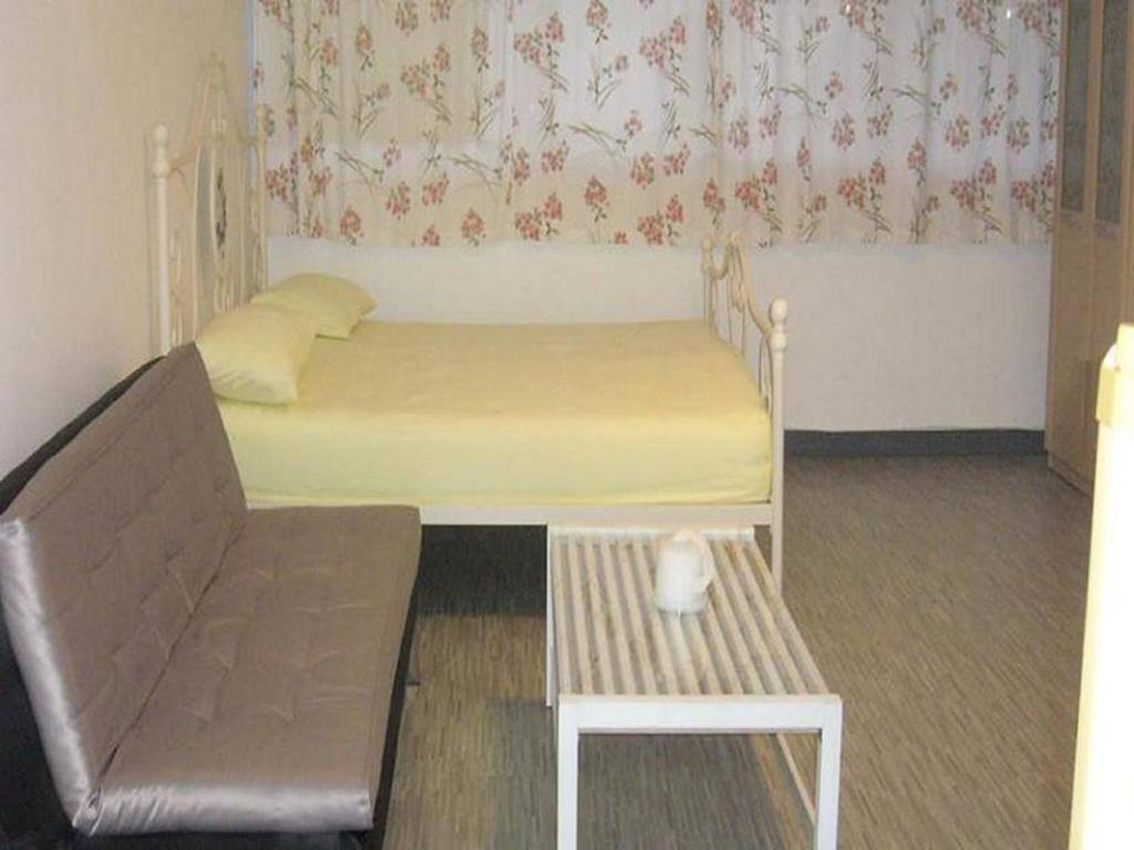 1 dormitorio pequeño con 1 cama y 1 silla en Room in Guest room - Impact Don Mueang Bangkok Guest House, en Thung Si Kan