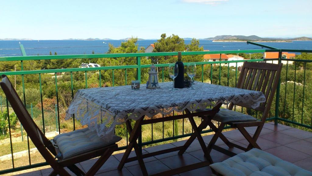 una mesa y sillas en un balcón con vistas al agua en Apartments Diana en Primošten