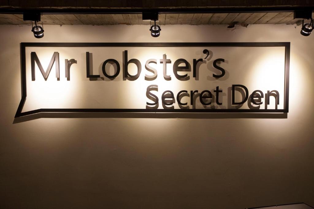 a sign for a mitzperers secret department on a wall at Mr. Lobster’s Secret Den design hostel in Taipei