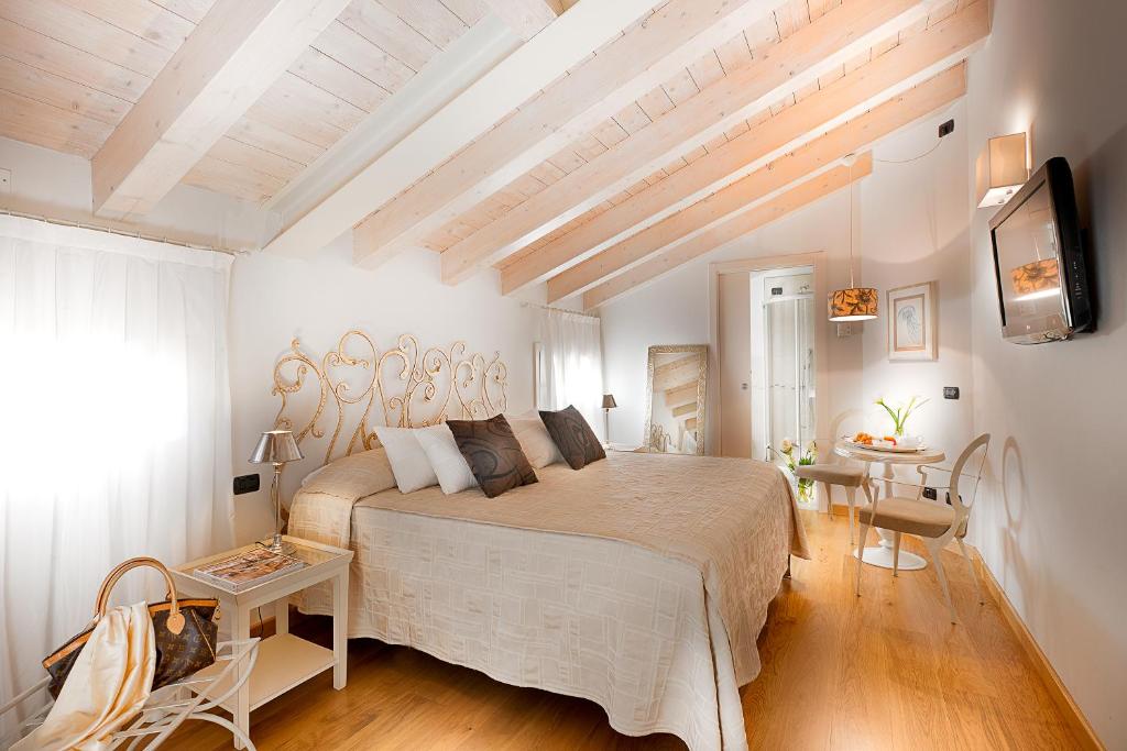 ein Schlafzimmer mit einem großen Bett und einem Tisch in der Unterkunft Affittacamere Boutique Room in Verona