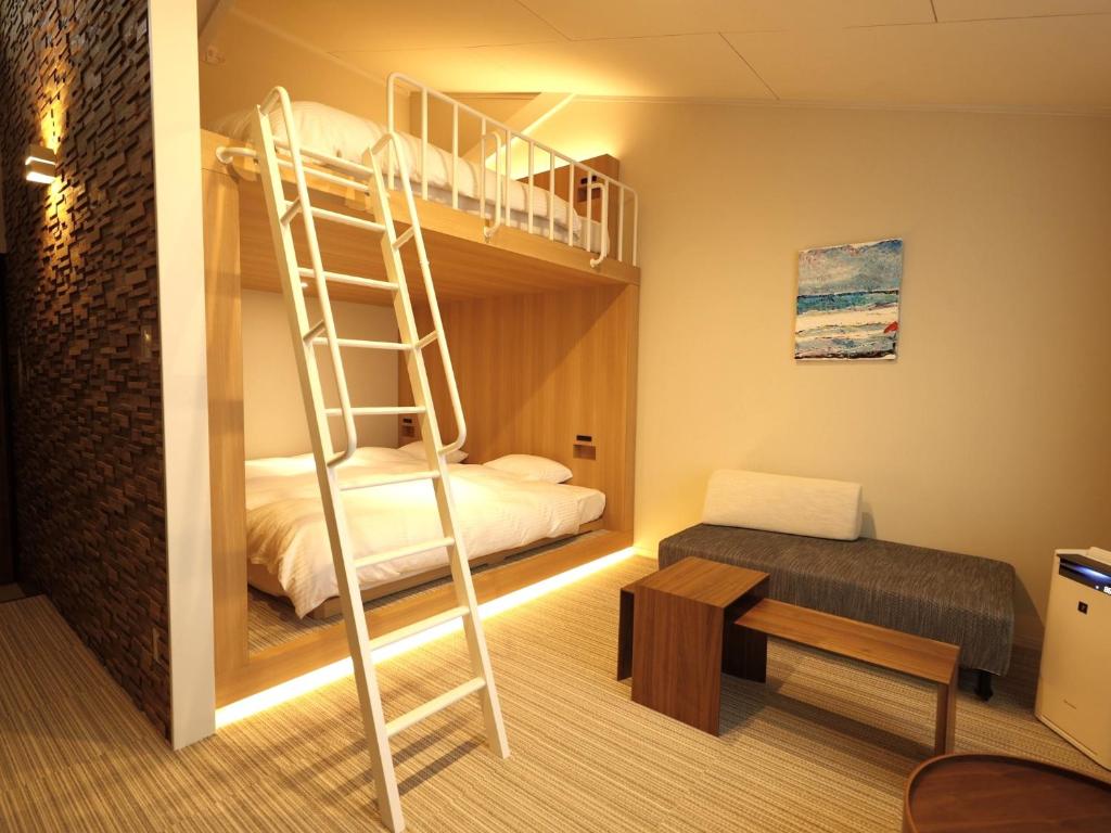 a bedroom with a bunk bed with a ladder at Chikura Tsunagu Hotel in Minamiboso