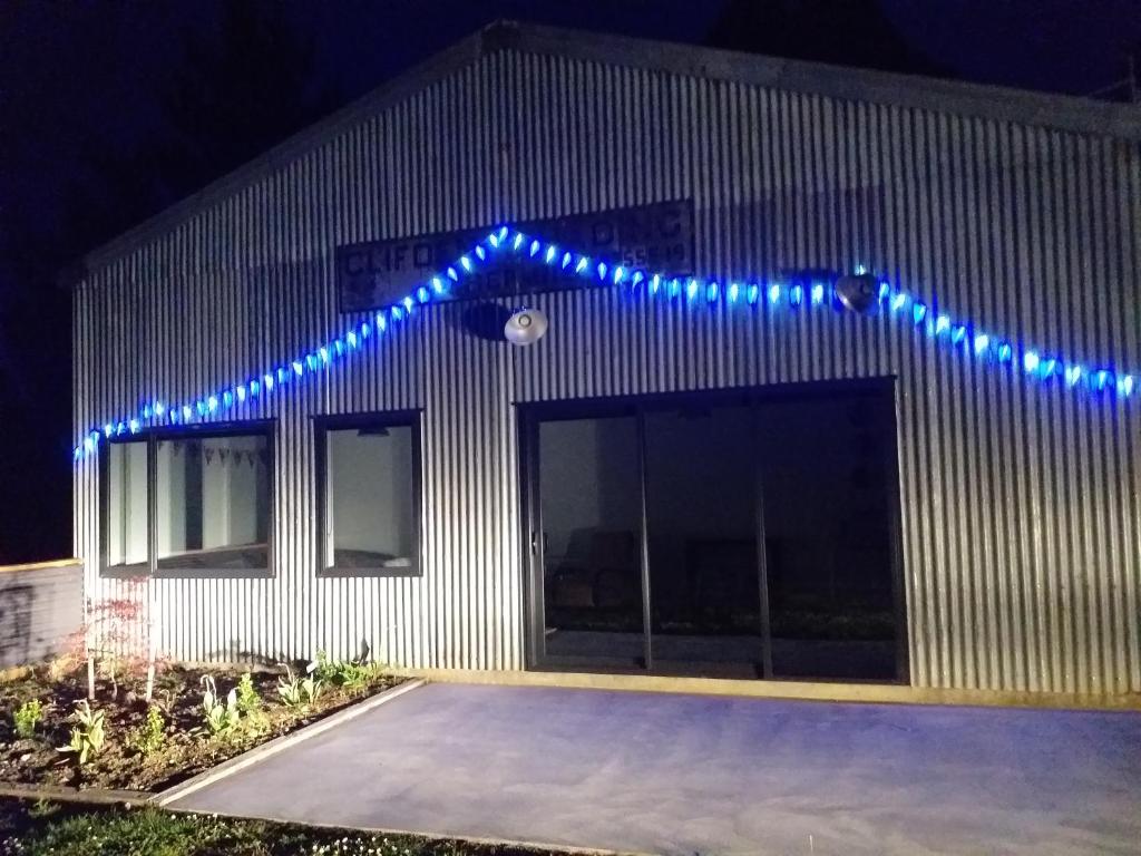 un edificio con luces azules en el lateral. en Clifden Pitstop en Eastern Bush