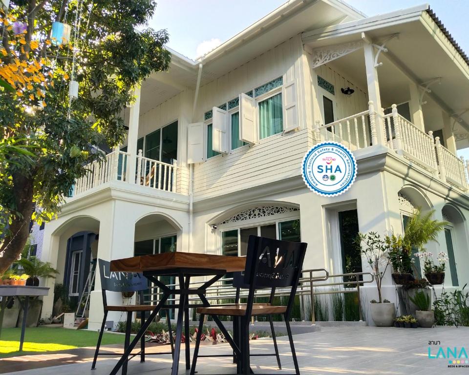 een tafel en stoelen voor een gebouw bij Lana Beds & Space in Chiang Mai