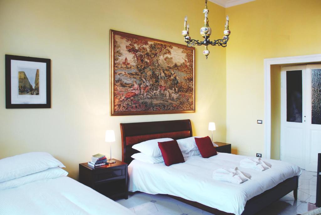 ローマにあるベッド＆ブレックファースト ピアッツァ ヴィットーリオ87のベッドルーム1室(ベッド2台付)が備わります。壁には絵画が飾られています。