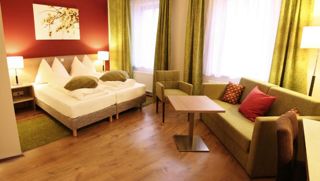 pokój hotelowy z 2 łóżkami i kanapą w obiekcie Gasthof Schmölz w mieście Sankt Christofen
