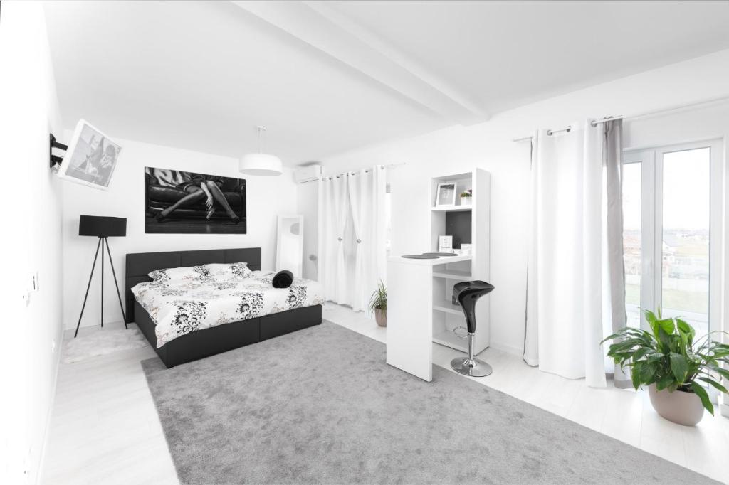 a white bedroom with a bed and a desk at REEAS APARTAMENT 13 in Chişoda
