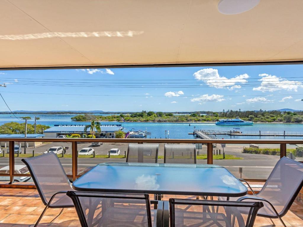 d'un balcon avec une table et des chaises et une vue sur l'eau. dans l'établissement Island View 4 Opposite Wallis Lake, à Forster
