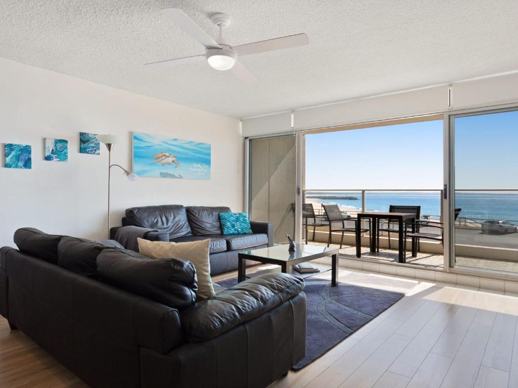 Una sala de estar con un sofá y vista al mar. en Oceanic 2 On Main Beach, en Forster
