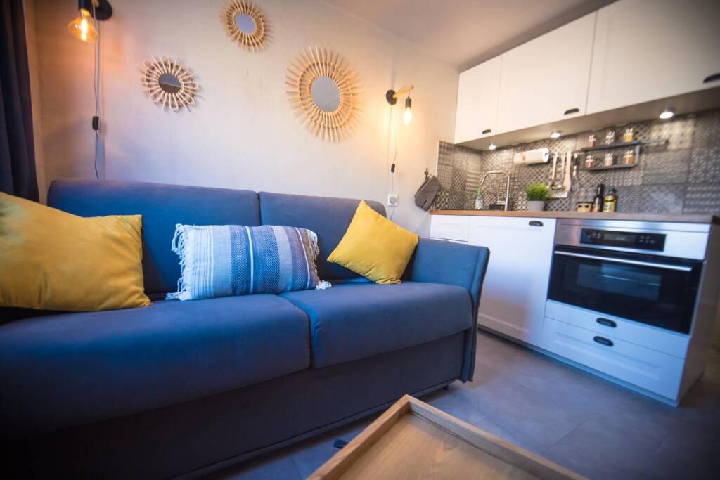 Il comprend un salon avec un canapé bleu et une cuisine. dans l'établissement Superbe -Appartement 2 personnes - Tignes le Lac - 813 - Le Palafour, à Tignes