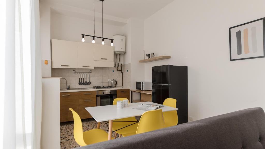 een keuken met een witte tafel en gele stoelen bij Italianway - Quarnaro 2 in Monza