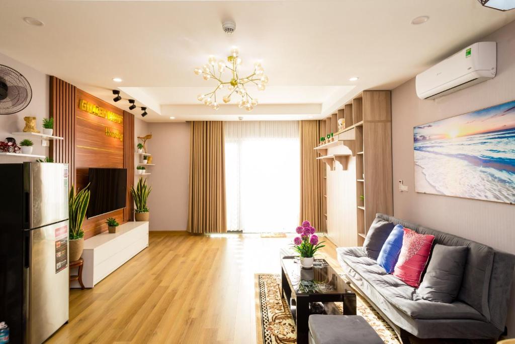 ein Wohnzimmer mit einem Sofa und einem Kronleuchter in der Unterkunft Căn hộ TMS Pullman cao cấp Studio có ban công view biển - Golden Wave Homestay in Quy Nhon