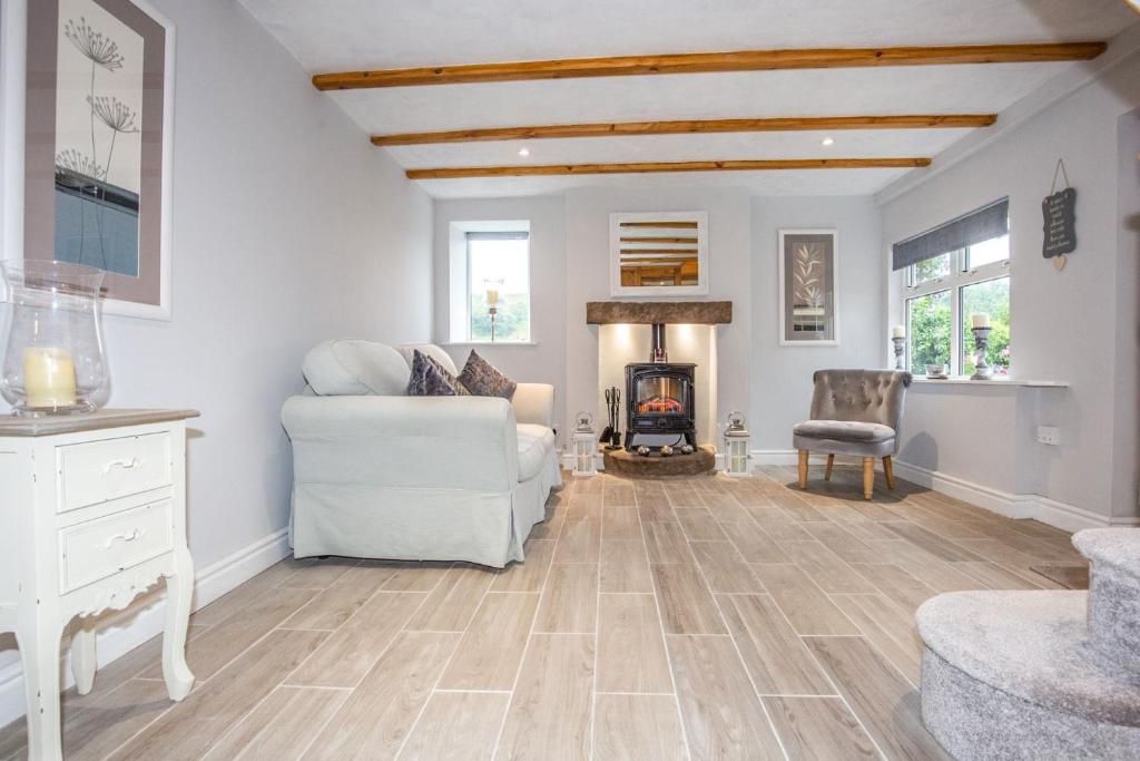 un soggiorno con divano bianco e camino di Snowdrop Cottage nr Alton Towers & Peak District, Sleeps 4+2 a Cauldon