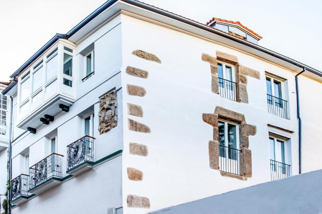 a white building with windows and balconies at HOTEL CAMINO do EUME in Puentedeume
