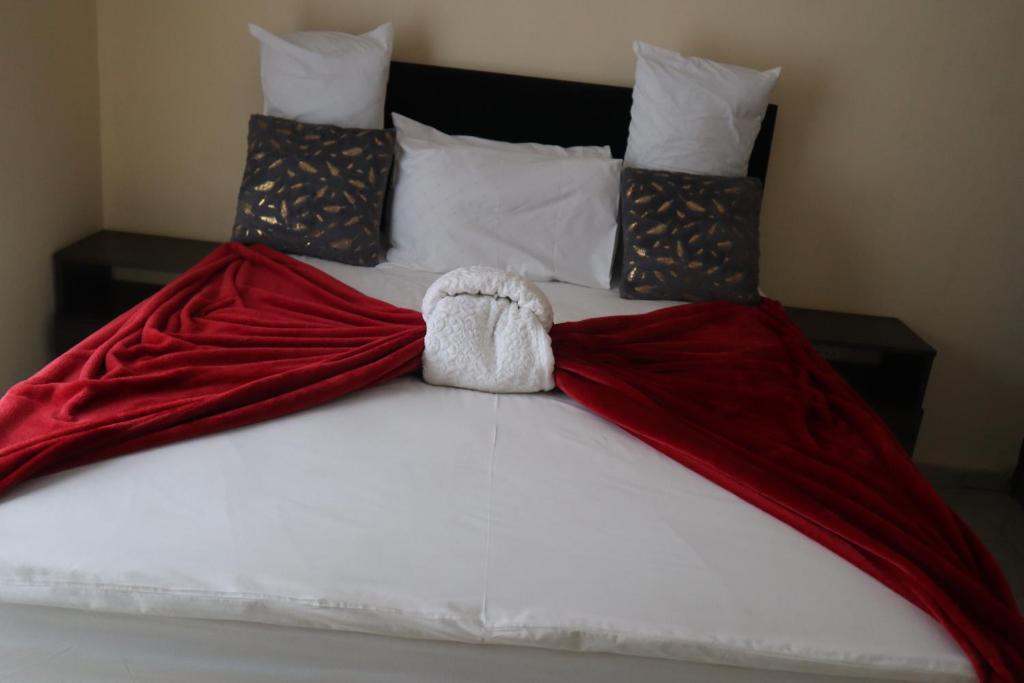 a bed with red and white blankets and pillows at KwaZikode Bed & Breakfast in Meyerton