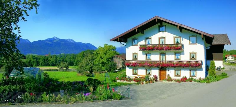 a large white building with flowers in front of it at Beim Most`l in Grabenstätt