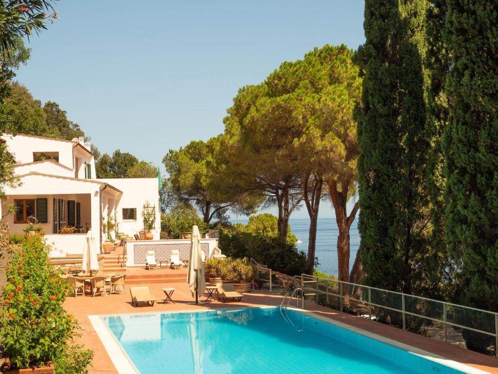 a swimming pool in front of a house at Villa LO SCHIOPPO vista mare in Marciana Marina