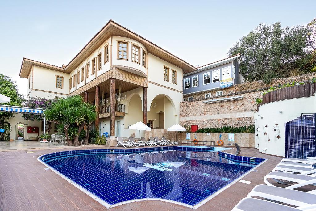 a house with a swimming pool in front of a house at Puding Hotel in Antalya