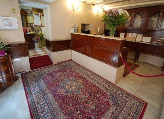 a lobby with a rug on the floor and a counter at Residenza Hotel San Maurizio in Venice