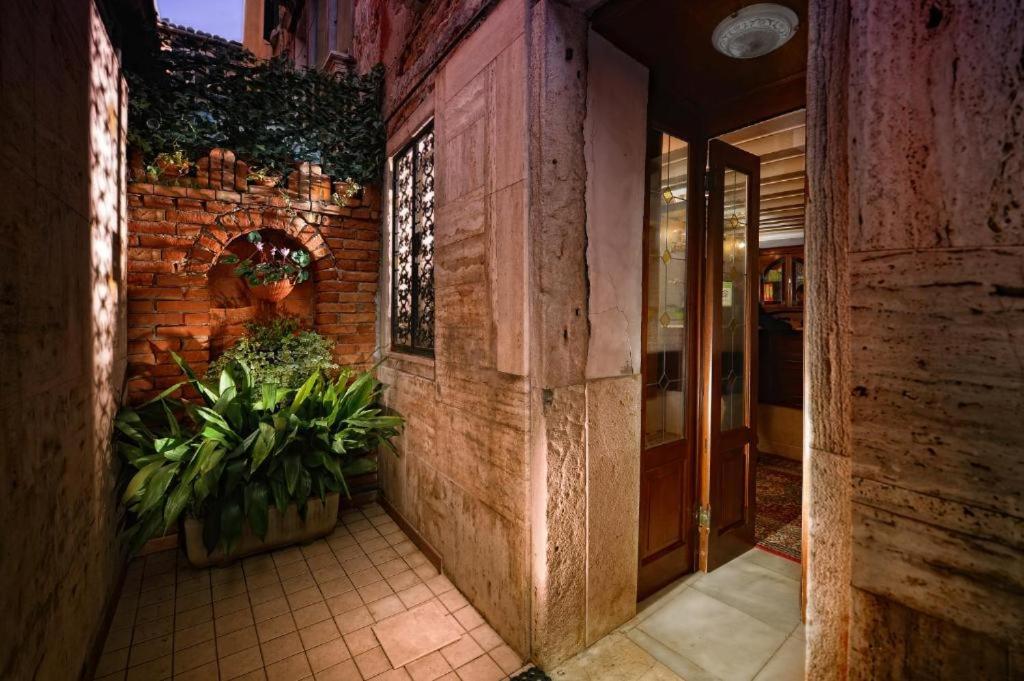 an entrance to a building with plants in a hallway at Residenza Hotel San Maurizio in Venice