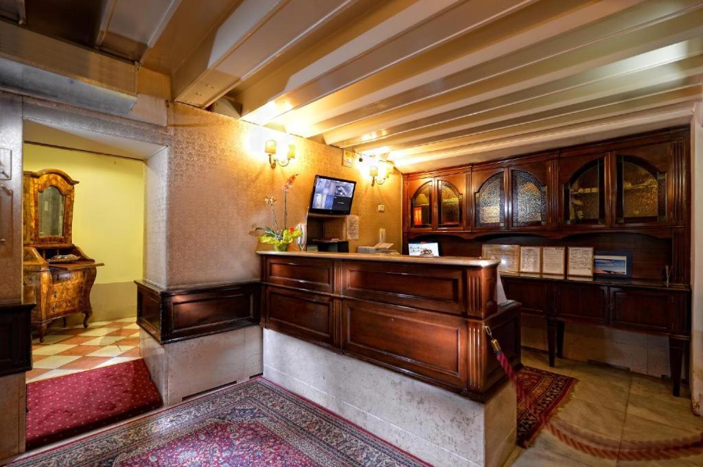 Habitación grande con armarios de madera y TV. en Residenza Hotel San Maurizio en Venecia