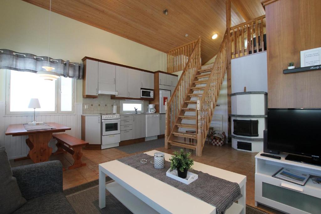 ein Wohnzimmer mit einer Küche und einer Treppe in einem Haus in der Unterkunft Metsätuuli 5 in Kalajoki