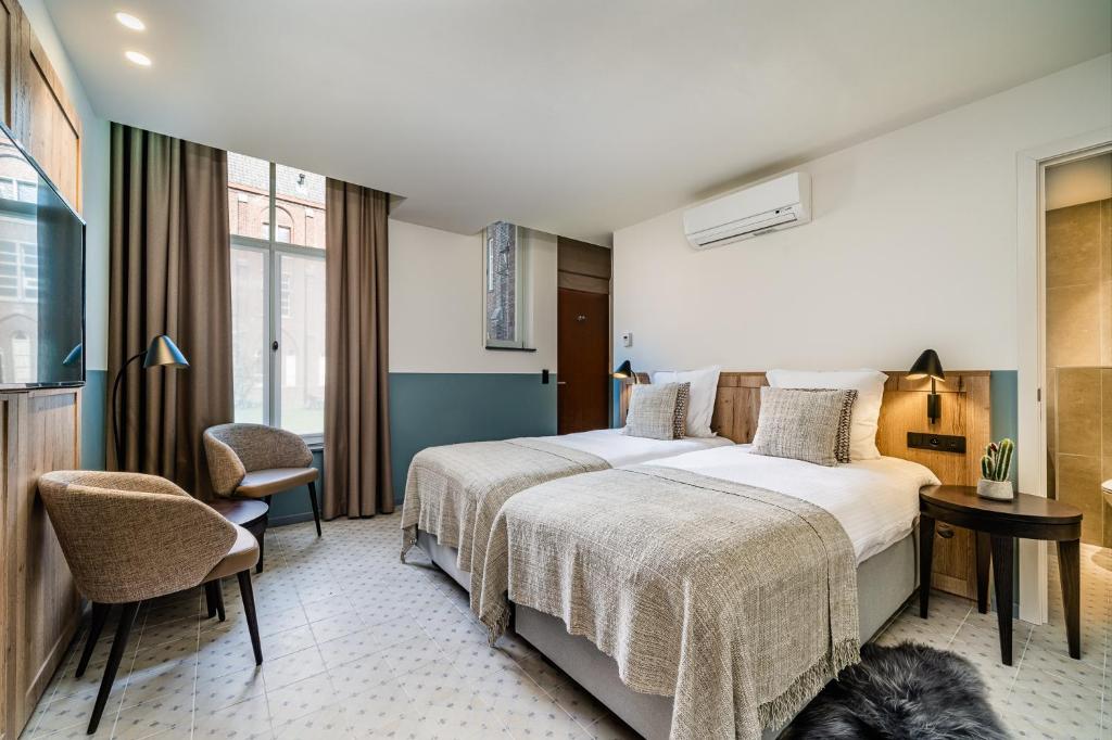 a bedroom with a bed and a dog in a room at Hotel Monasterium PoortAckere Ghent in Ghent