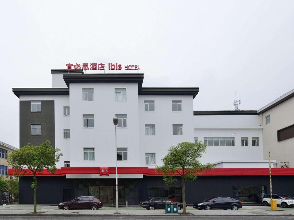Un bâtiment blanc avec un panneau en haut dans l'établissement Ibis Shanghai New Hongqiao, à Shanghai