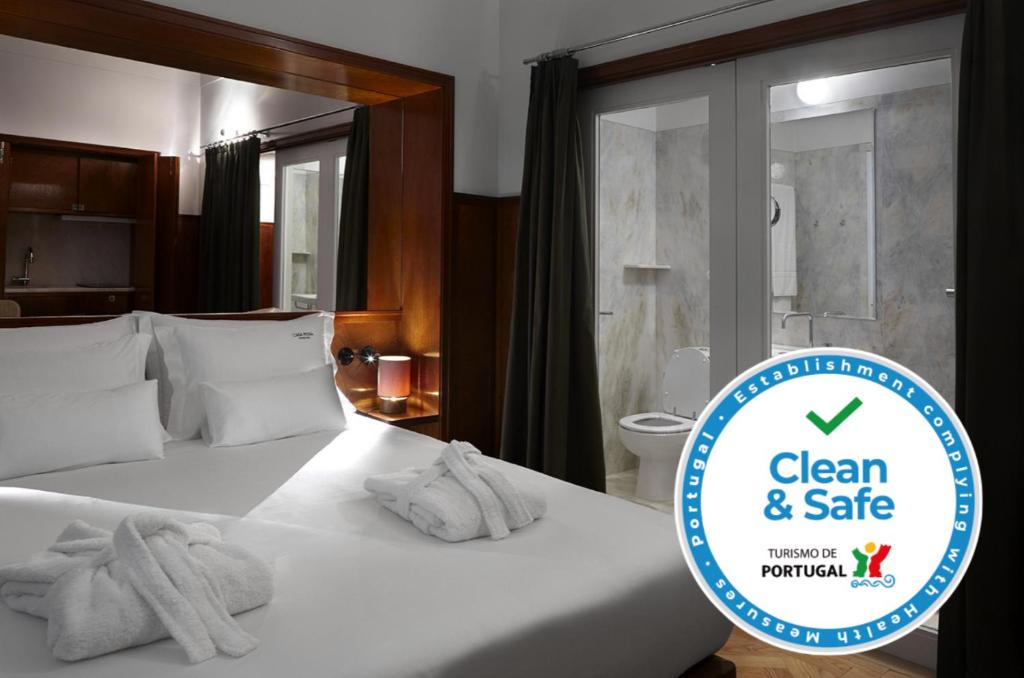 een hotelkamer met een bed met handdoeken erop bij Casa Rosa in Porto