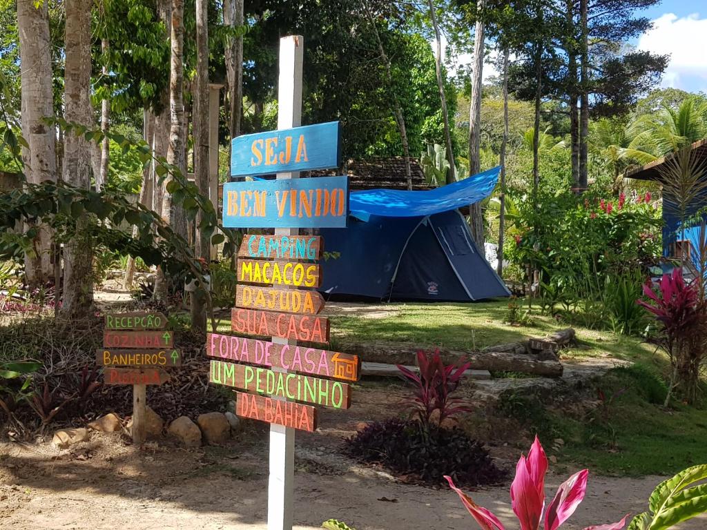 znak z wieloma różnymi znakami przed namiotem w obiekcie Camping Macacos d'ajuda w mieście Porto Seguro