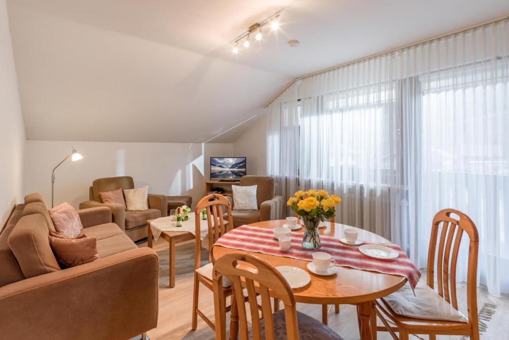 uma sala de estar com uma mesa e um sofá em Ferienwohnanlage Oberaudorf E7 mit 2 Schlafzimmer und Hallenbad em Oberaudorf