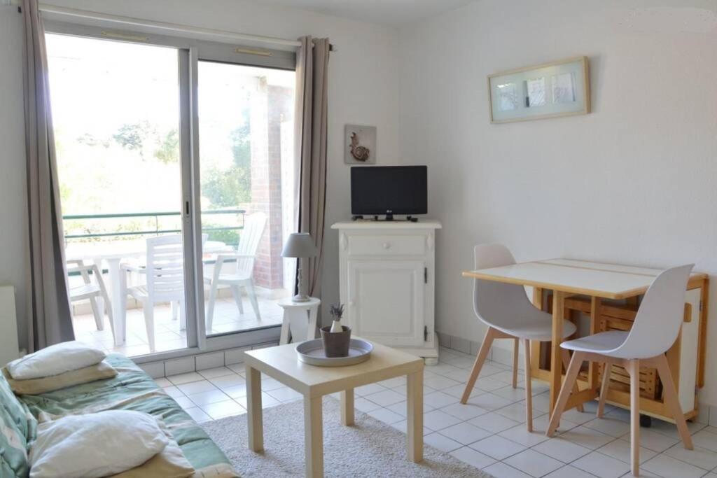 uma sala de estar com uma mesa e uma sala de jantar em Studio - 700m plage port - 200m golf - wifi - piscine em Pornic