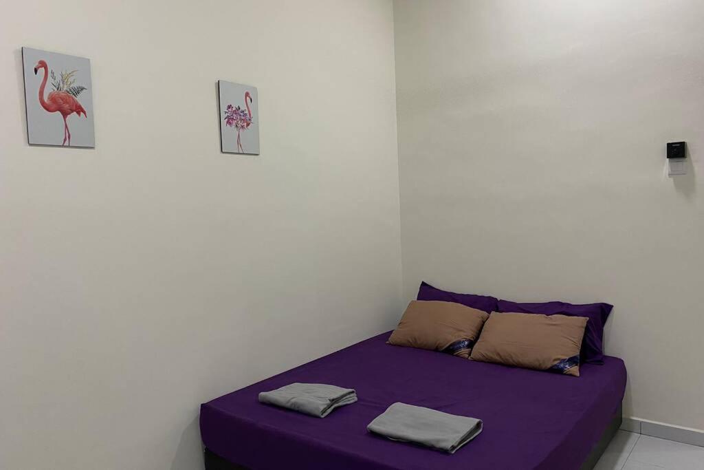 a bedroom with a purple bed with two pillows at Twilight Imani Homestay Changlun in Changlun