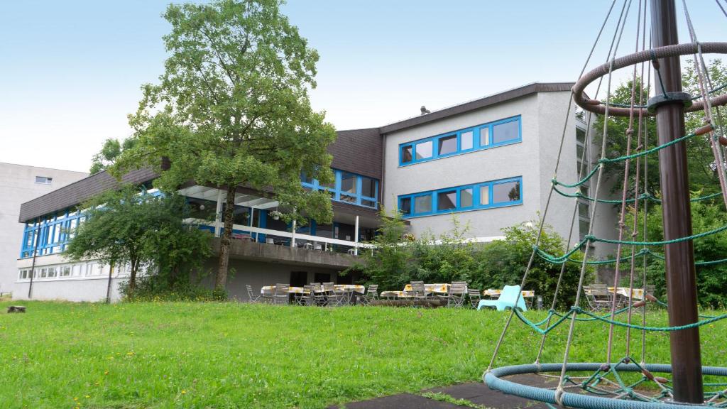 un edificio con parque infantil frente a un edificio en St. Gallen Youth Hostel, en St. Gallen