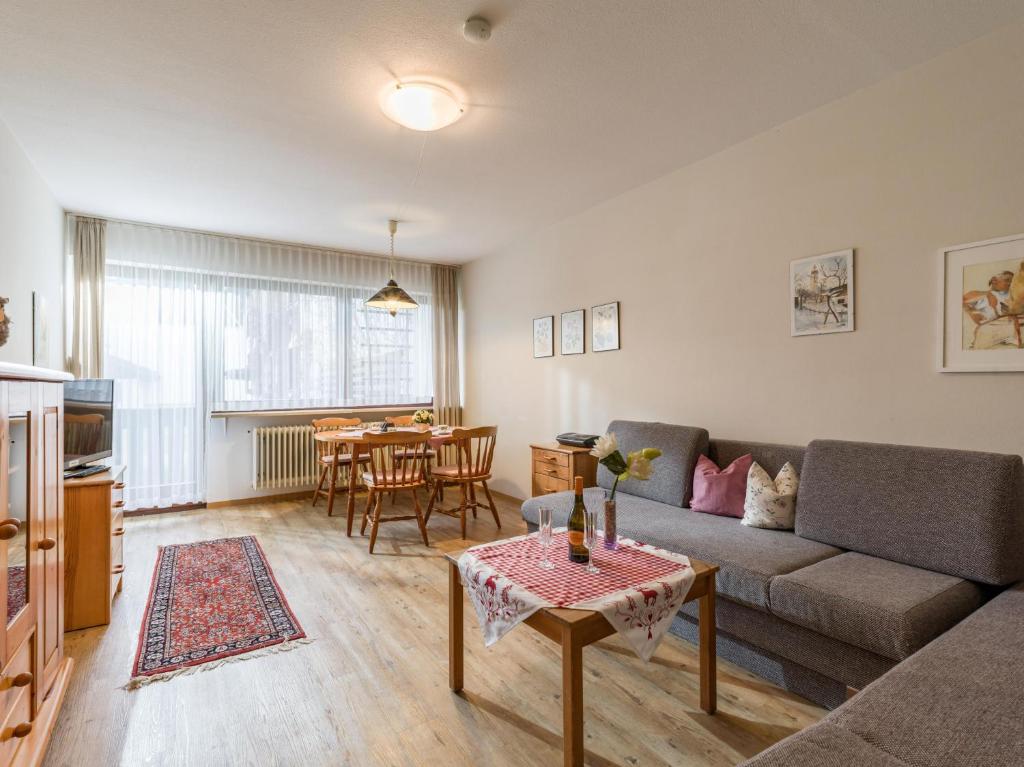 ein Wohnzimmer mit einem Sofa und einem Tisch in der Unterkunft Ferienwohnanlage Oberaudorf E1 mit Hallenbad und Sauna in Oberaudorf
