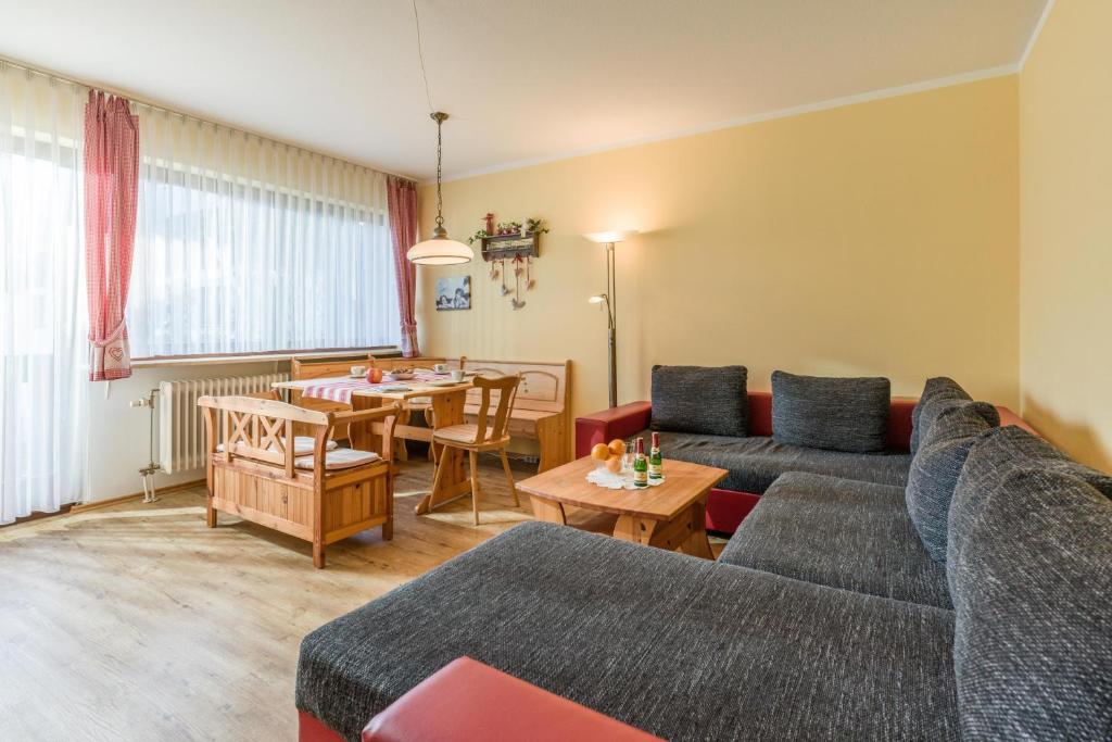 een woonkamer met een bank en een tafel bij Ferienwohnanlage Oberaudorf E5 mit Hallenbad und Sauna in Oberaudorf