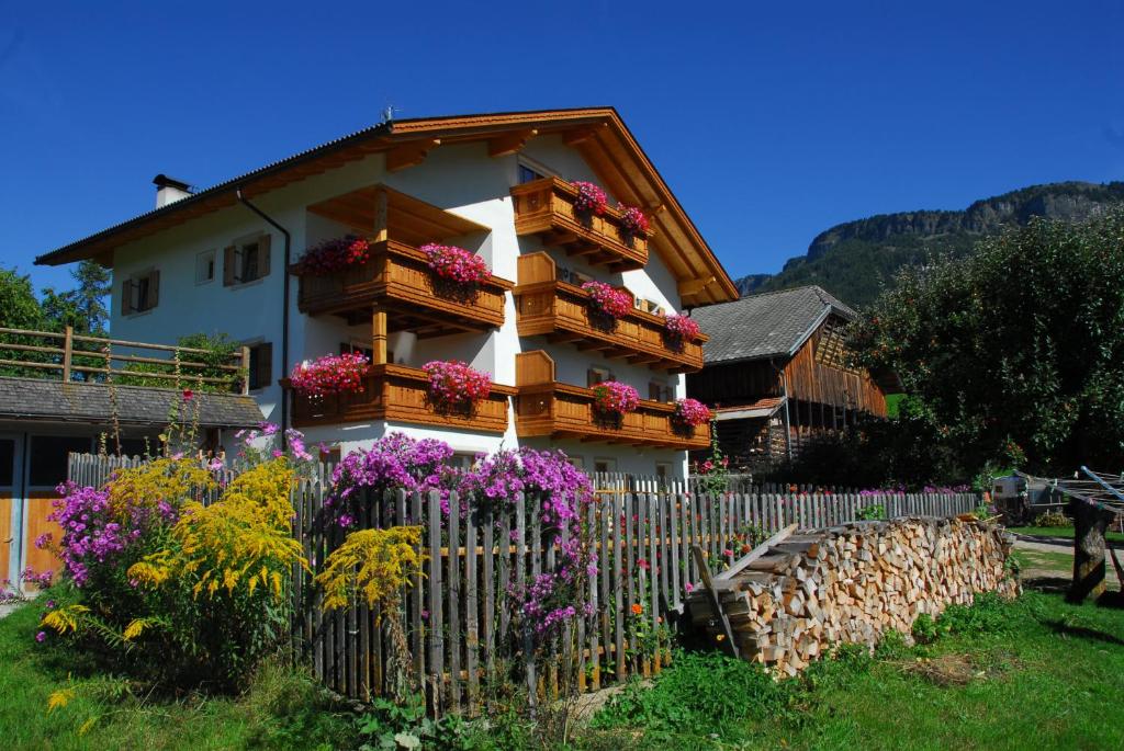 een huis met bloemen voor een hek bij Singerhof in Castelrotto