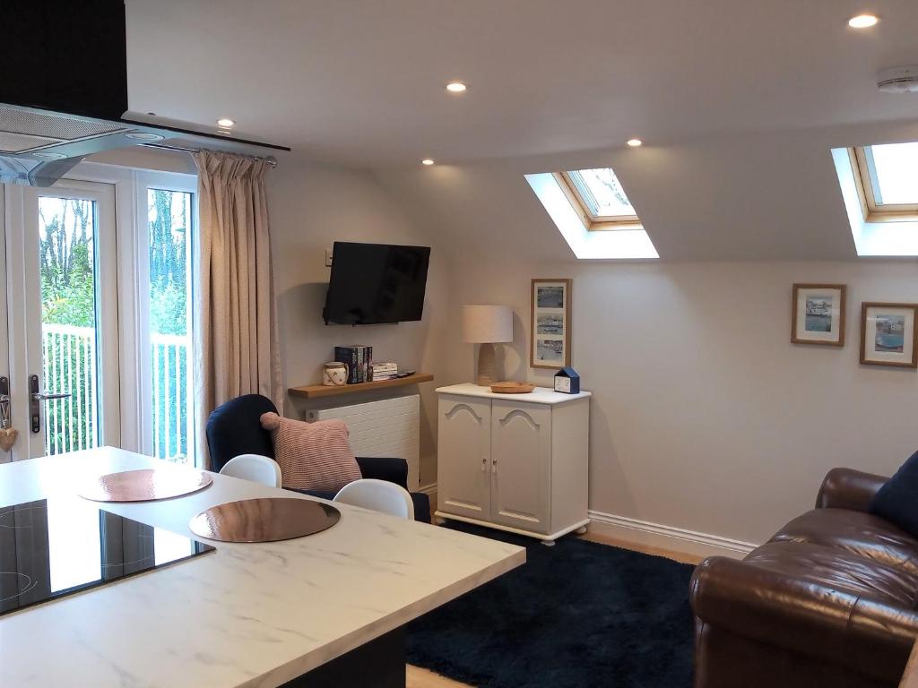 a living room with skylights and a table and chairs at The Captains Quarters, Woolsery in Bideford