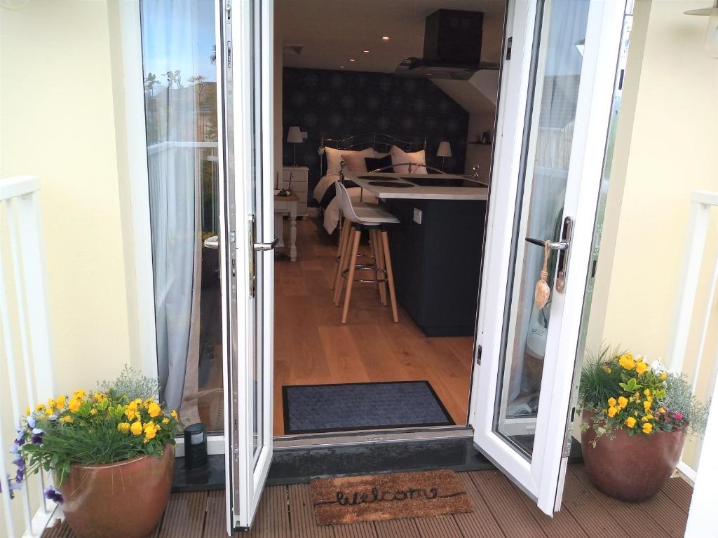 an open door into a kitchen with potted plants at The Captains Quarters, Woolsery in Bideford