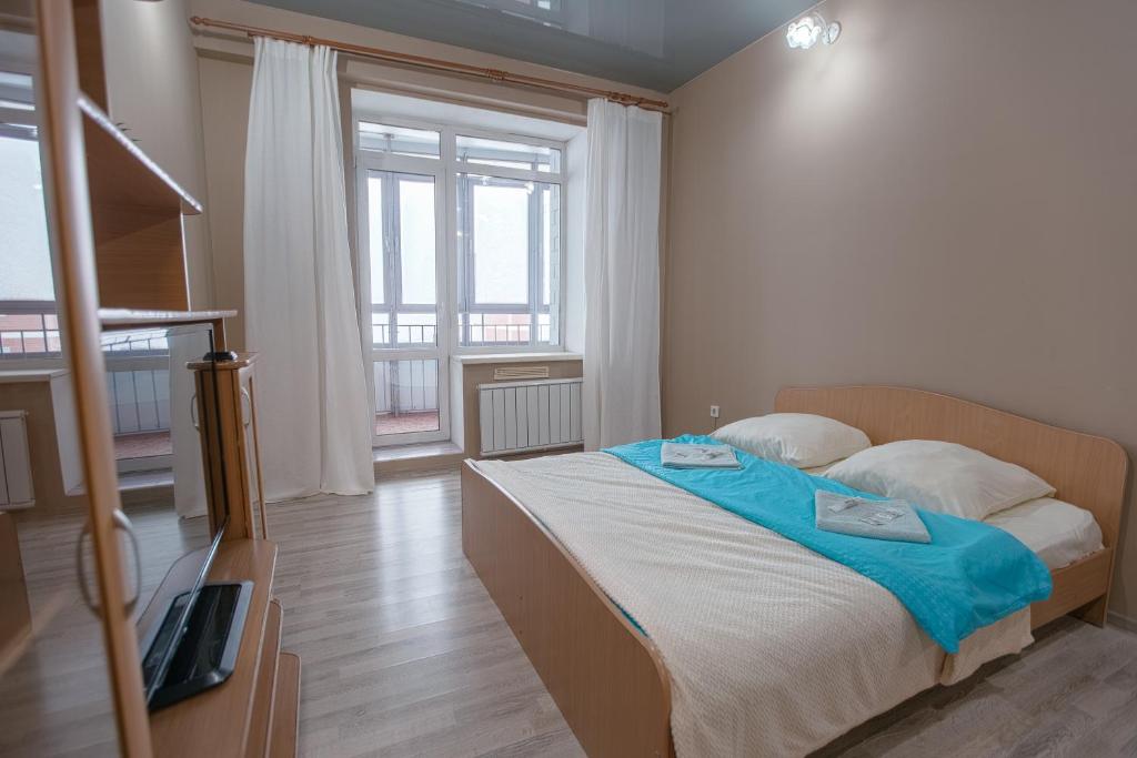 a bedroom with a bed and a large window at Welcome Home Apartments Dalnevostochnaya 106 in Irkutsk