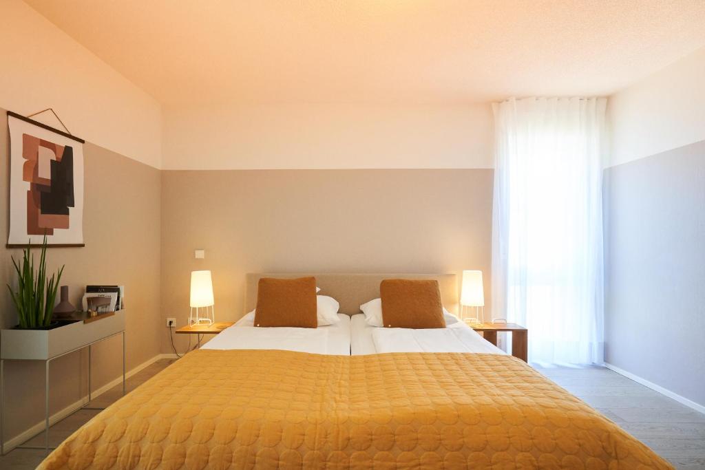 ein Schlafzimmer mit einem großen gelben Bett mit zwei Kissen in der Unterkunft Gästehaus am Wasserschloss & Restaurant Wasserschloss Inzlingen in Inzlingen