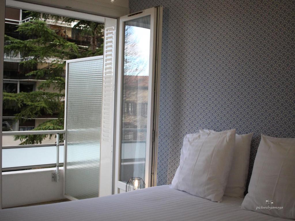 a bedroom with a bed and a large window at Espace Cocooning in Chamalières