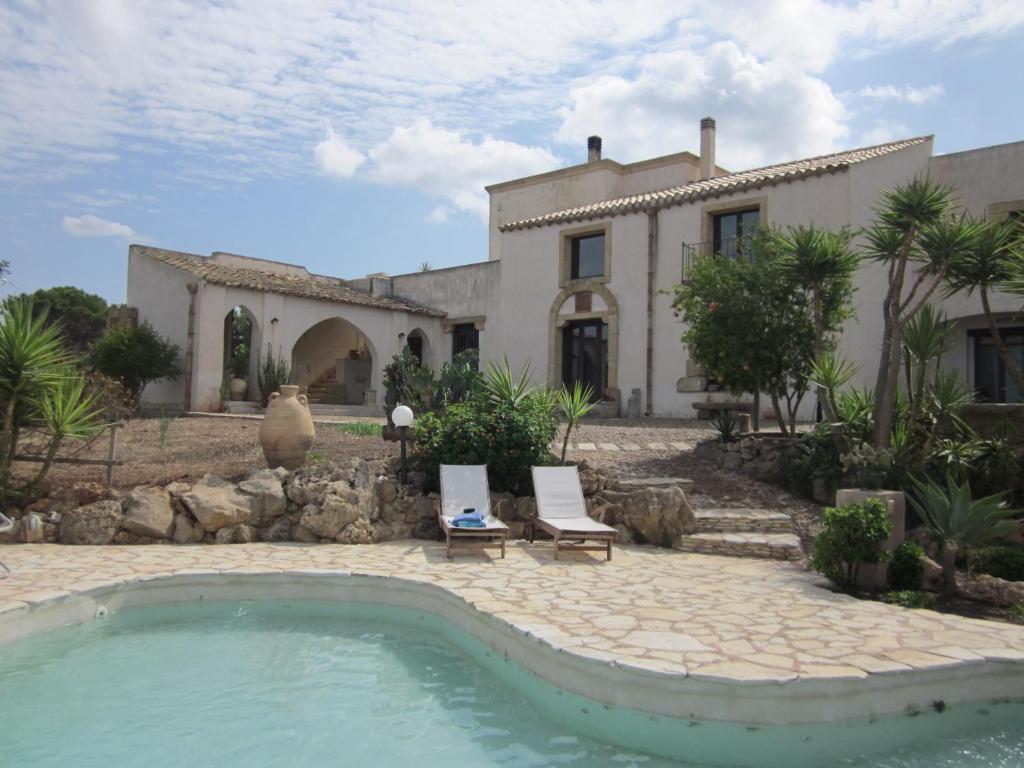 a house with a swimming pool in front of a house at Casale Alma in Marsala