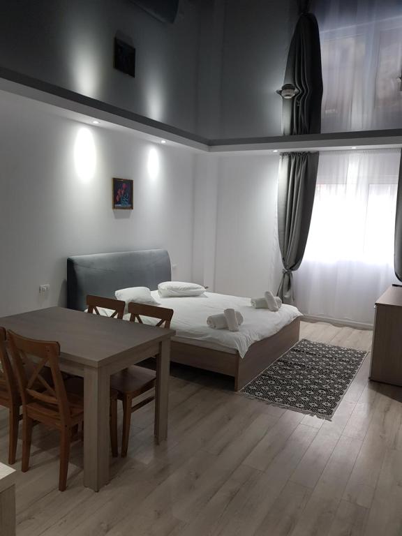 - une chambre avec un lit, une table et des chaises dans l'établissement Happy Residence, à Vişeu de Sus