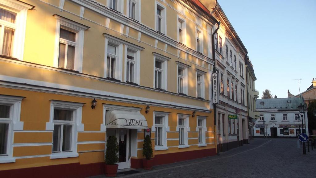 un edificio amarillo con un cartel para un hotel en Hotel Trumf, en Mladá Boleslav